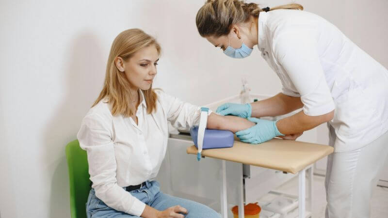 A nurse performs a blood test.